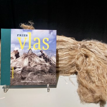 Boek 'Fries Vlas' met op de achtergrond vlas
