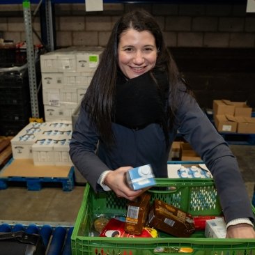 Persoon met een krat vol boodschappen
